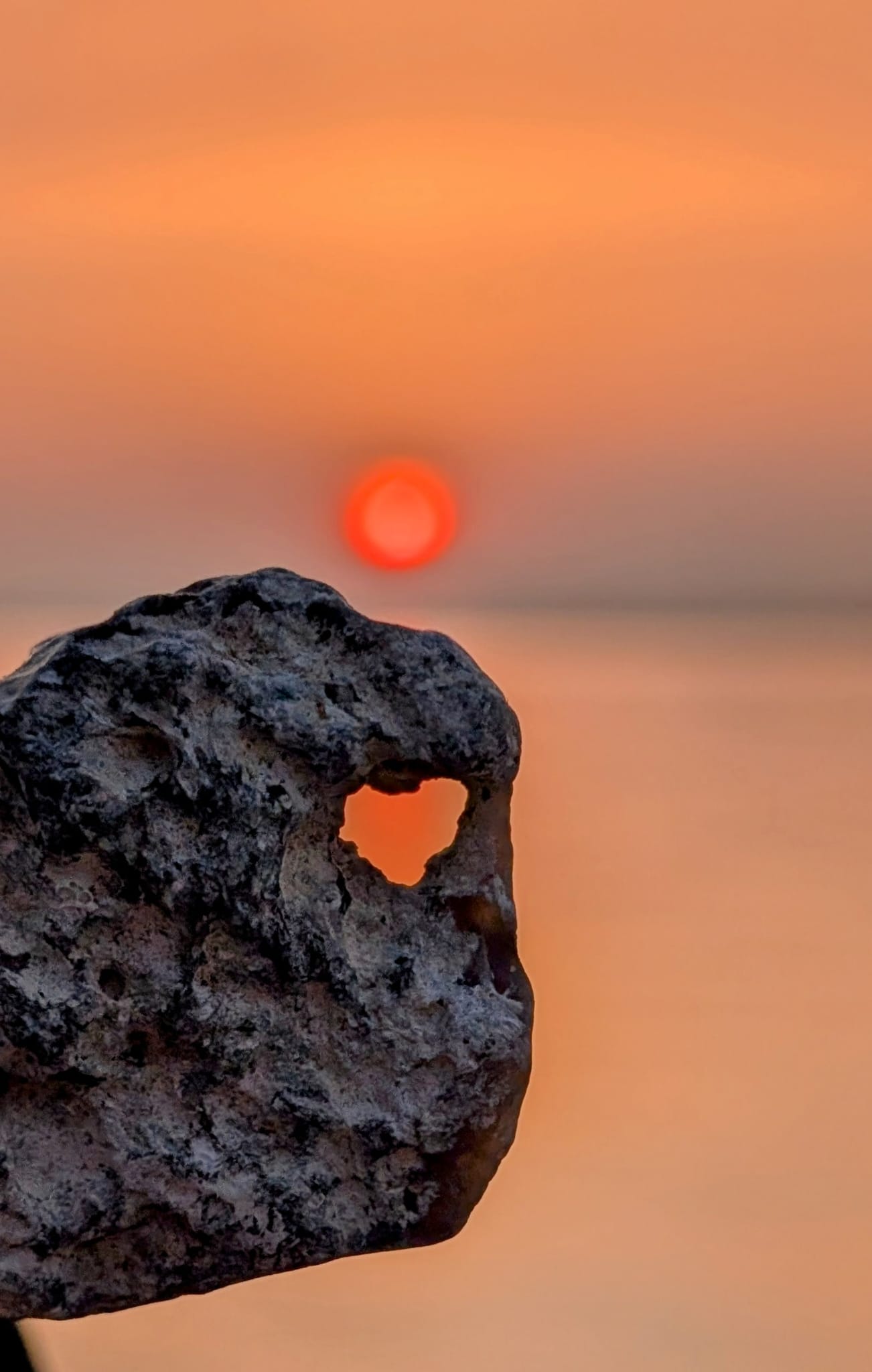 Felsen mit Sonnenloch bei Sonnenuntergang